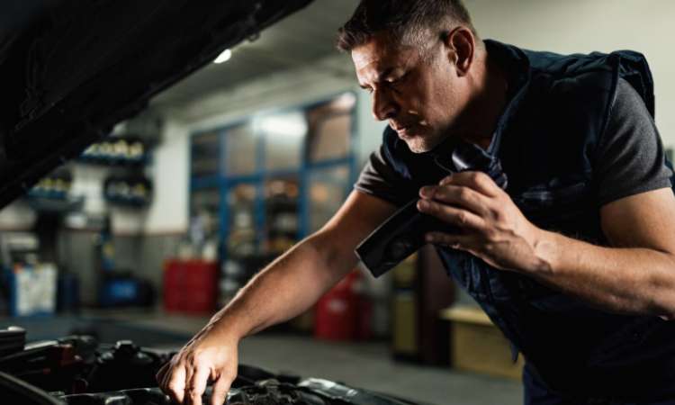 hombre revisando los componentes del motor de carro