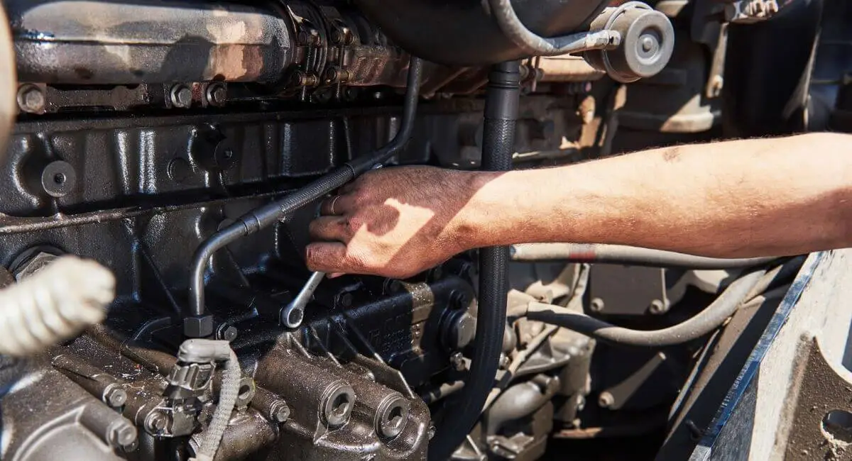mecánico revisando caja de cambios de camión en taller