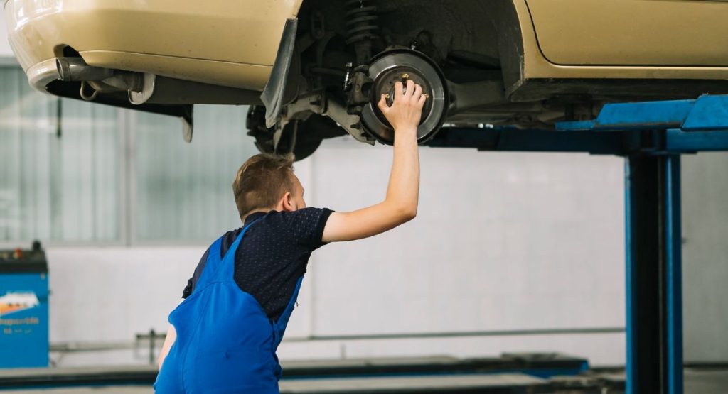 especialista revisa sistema de suspensión de vehículo